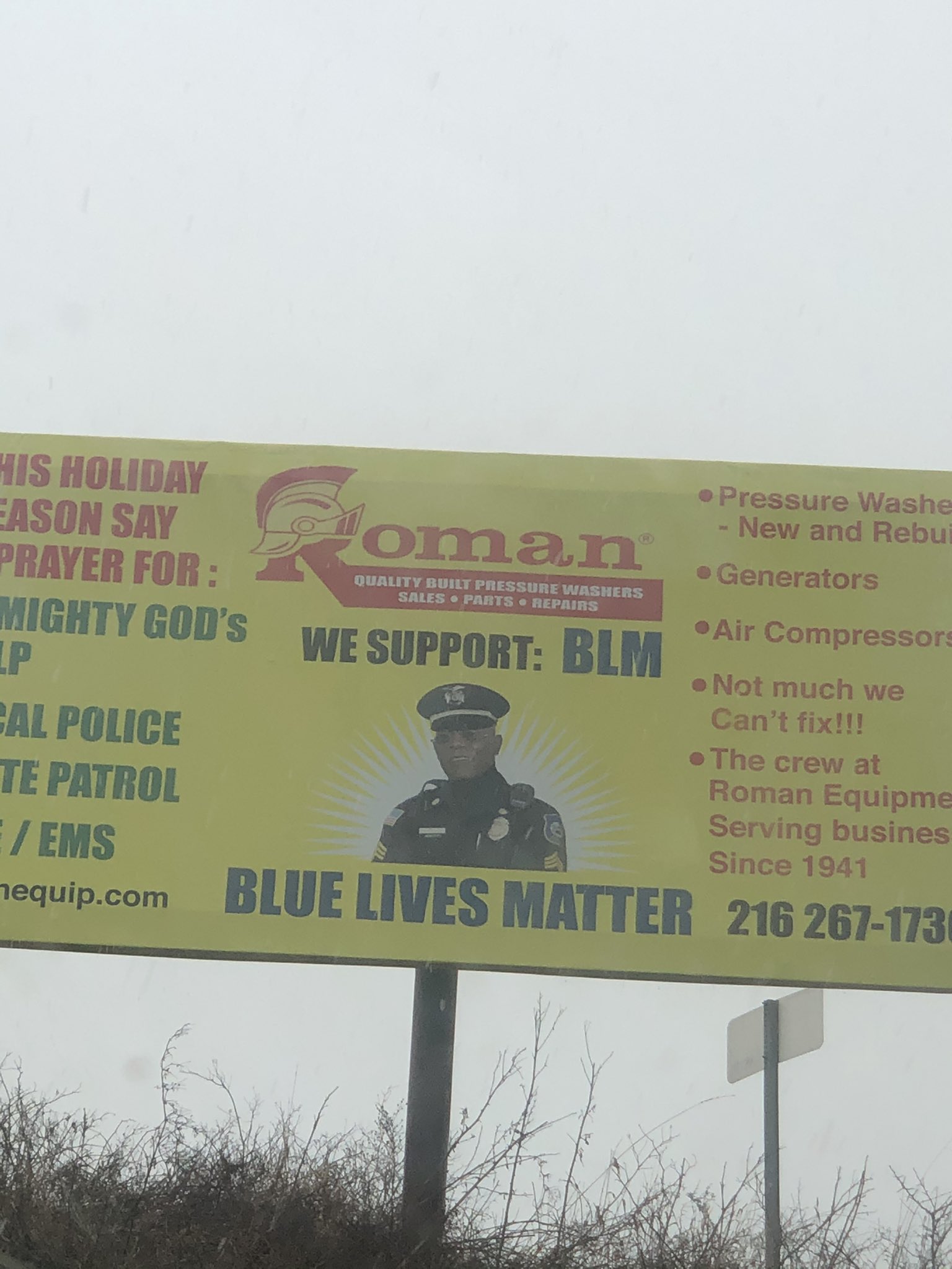 This is a picture of a billboard, on the billboard words write out "We Support: BLM" under these words is a picture of actor Samuel L. Jackson in a police officer uniform. Under the picture, words write out "Blue Lives Matter"