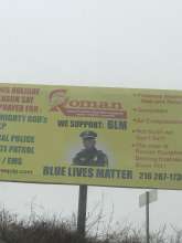 This is a picture of a billboard, on the billboard words write out "We Support: BLM" under these words is a picture of actor Samuel L. Jackson in a police officer uniform. Under the picture, words write out "Blue Lives Matter"