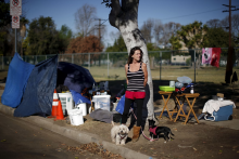 Woman standing next to her only home